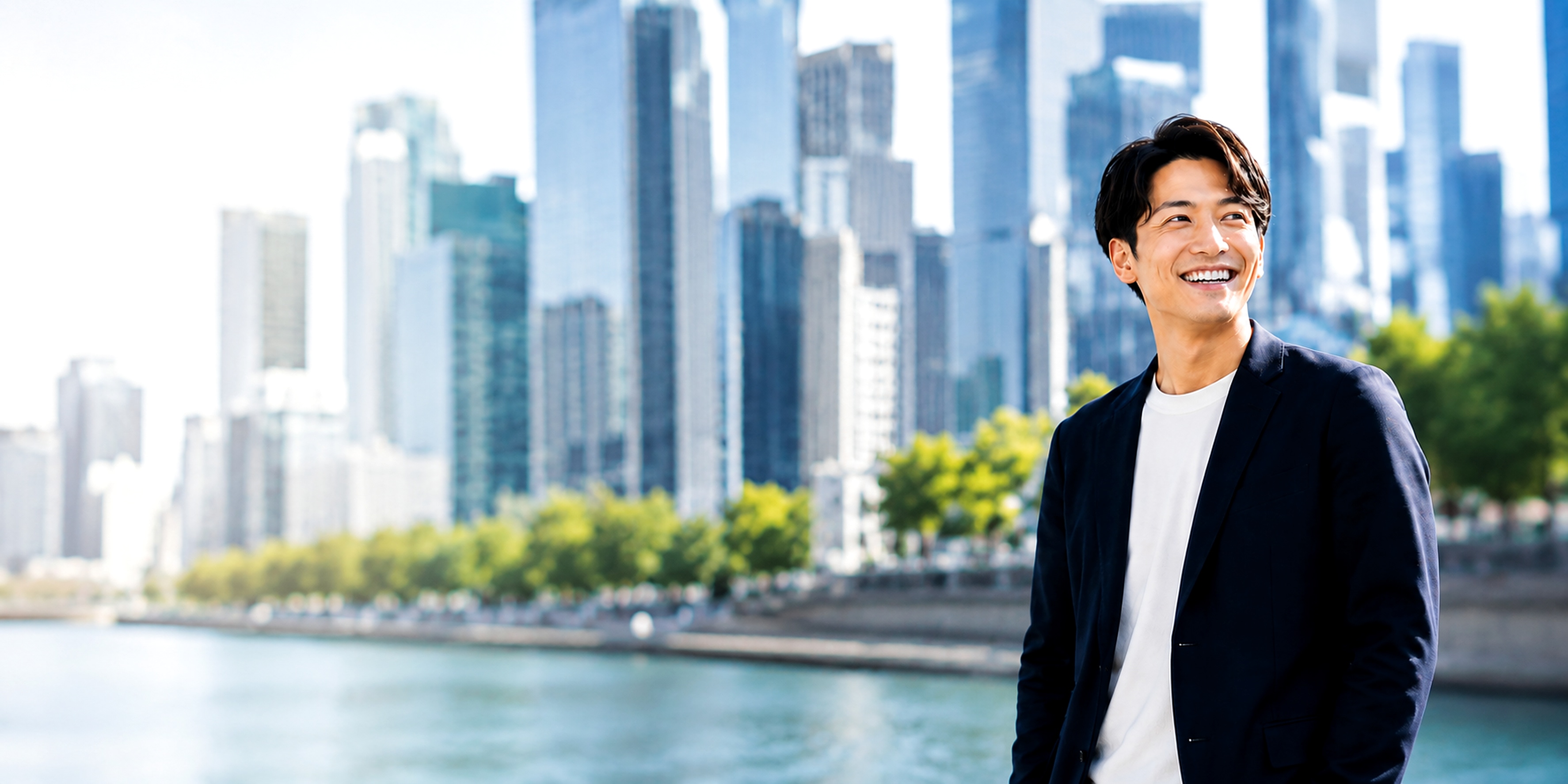 スーツの男性が都市の水辺で明るい表情で前を見ている